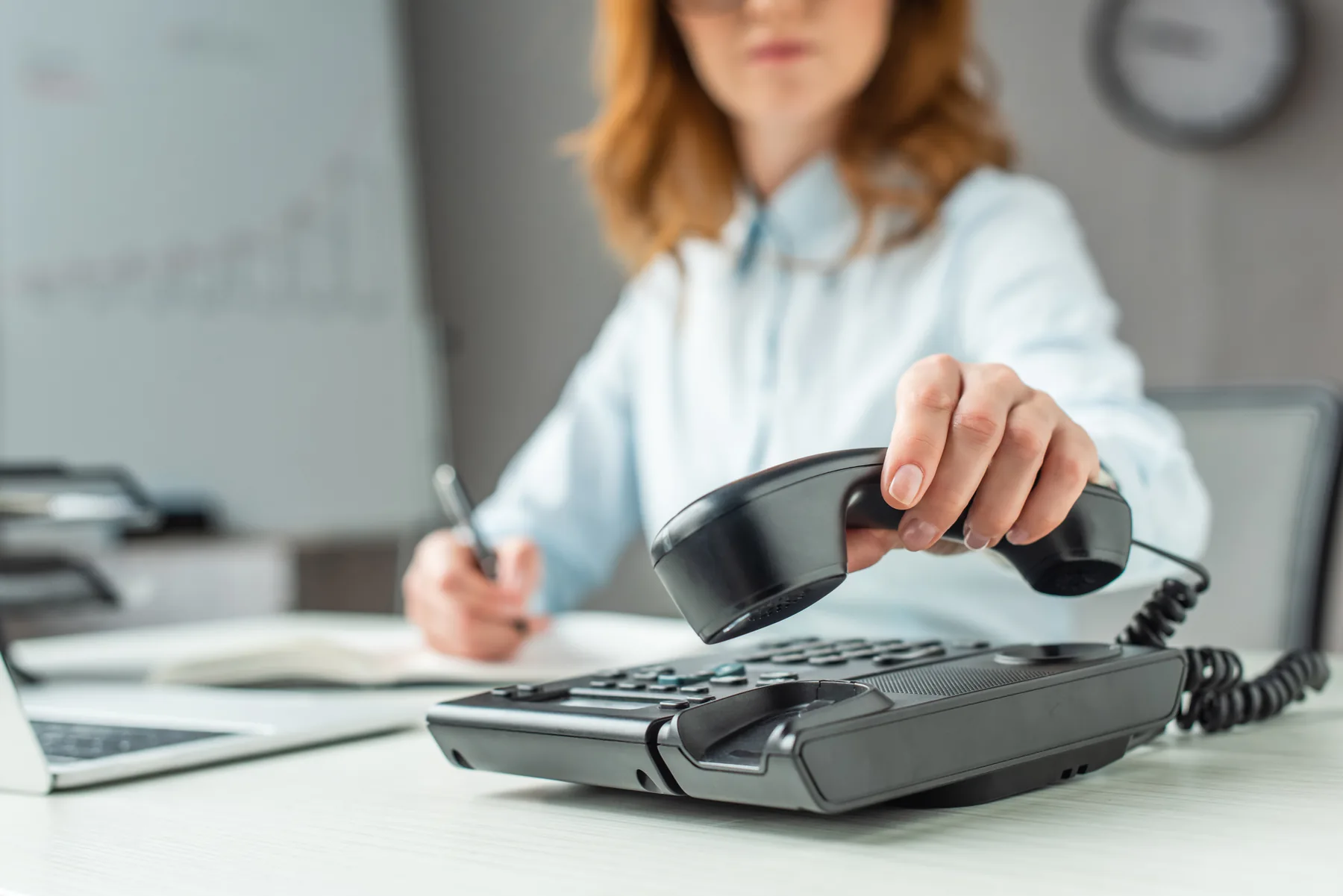 Business professional answering an office phone