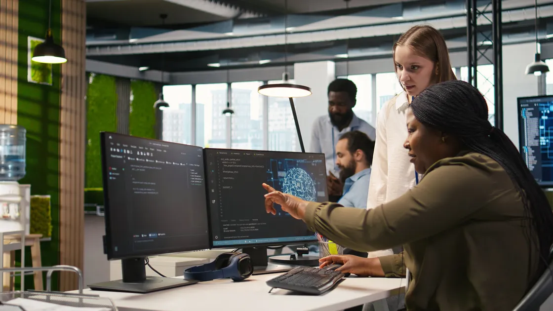 Two people working together at laptop computers.